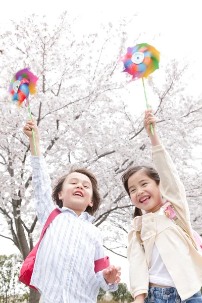 Szczęśliwy Japoński Uczennice Pinwheels Wiosennym Parku — Zdjęcie stockowe