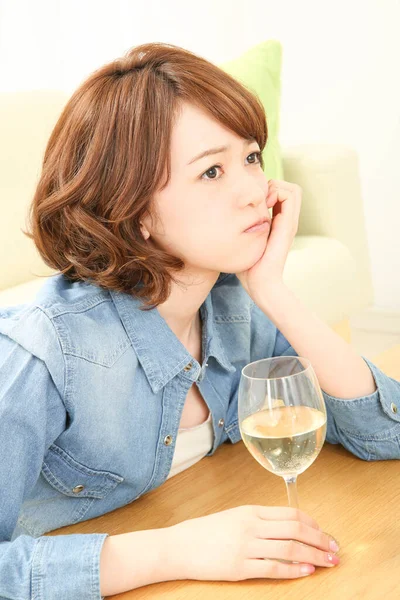 自宅でワインを飲む悲しいアジア女性の肖像画 — ストック写真
