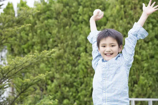 Parkta topu olan mutlu Asyalı küçük çocuk.