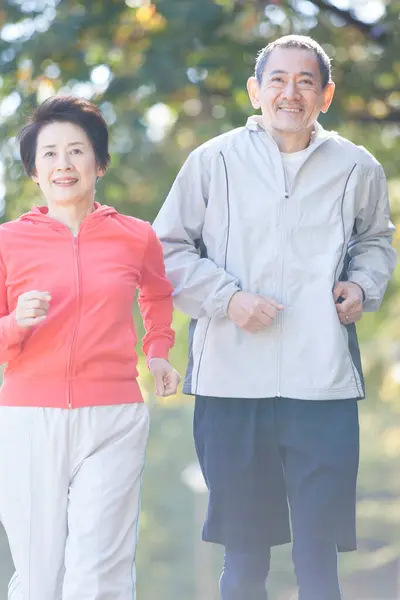 asian senior couple jogging in park