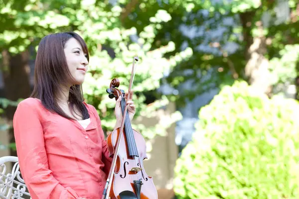 Kemanı olan genç Asyalı kadın.