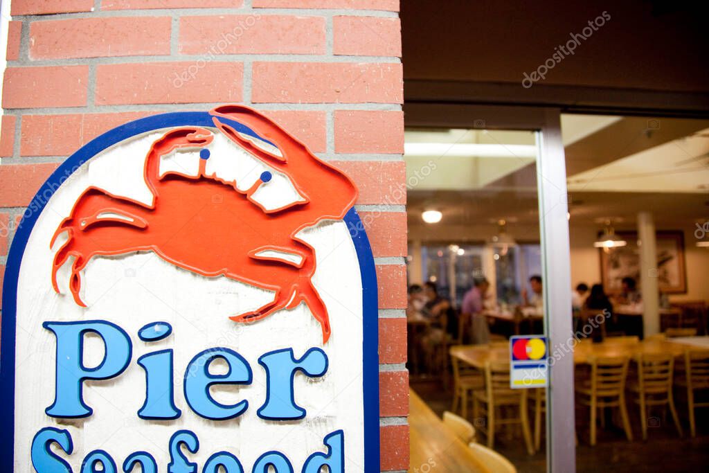 Red crab sign marking seafood restaurant entrance evening
