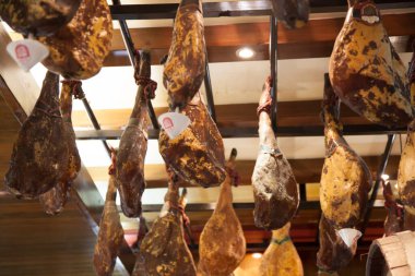 Tavandan sarkan kurutulmuş jambon bacakları.