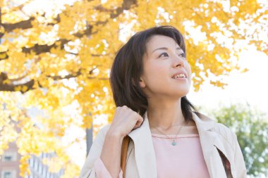 Güz parkında yürüyen güzel bir Japon kadın. 