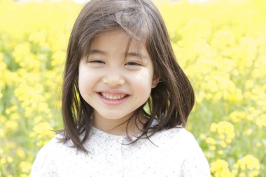 Parkta gülümseyen küçük Asyalı kız.