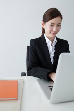 Dizüstü bilgisayar kullanan kendine güvenen Japon iş kadını.