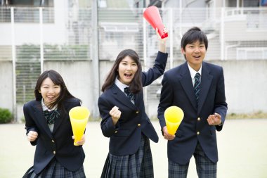 Dışarıda vakit geçirirken üniforma giyen mutlu Asyalı öğrenciler. 