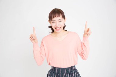 Beyaz arka planda parmaklarını gösteren Asyalı genç bir kadının portresi