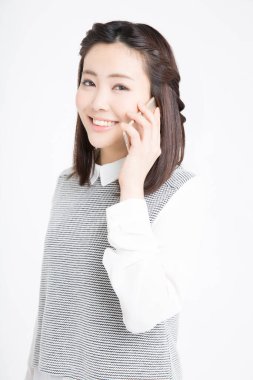 Akıllı telefondan konuşan güzel Japon kadının stüdyo portresi.