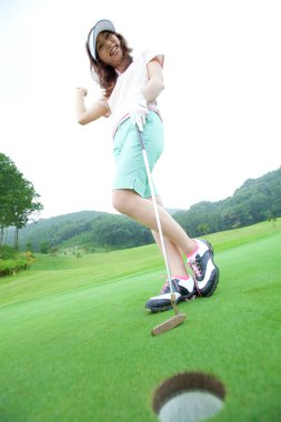 Golf oynayan genç bir kadın