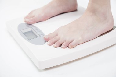 Kadın ayağı terazide, yakın çekim.