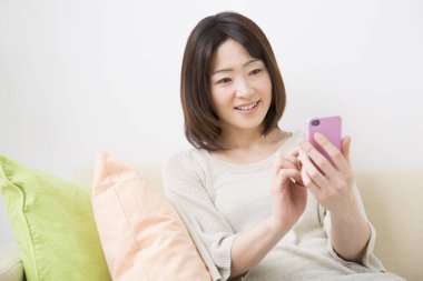 kadın kanepe üstünde hareket eden telefon ile 