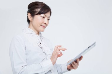 Beyaz arkaplanda dijital tabletle çalışan kadın 