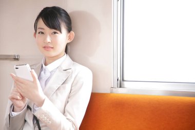 Metroda cep telefonu olan bir kadın.