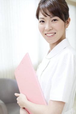 Pembe klasörlü genç gülümseyen Asyalı kadın. 