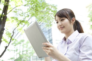 Şehirde tablet kullanan genç iş kadını