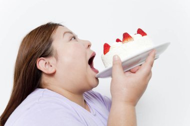 Beyaz arka planda pastası olan şişman Japon kadının stüdyo portresi