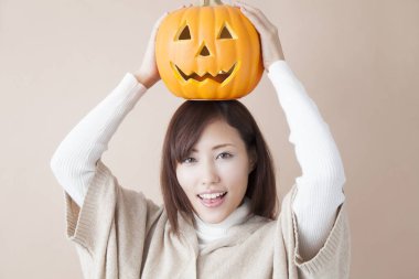 Cadılar bayramı için balkabaklı Asyalı kadın, stüdyo fotoğrafı.