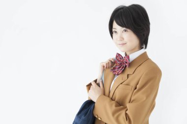 Okul üniformalı Japon bir kızın çanta taşıyan portresi.