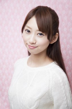 Stüdyoda poz veren Asyalı genç kadın. 