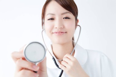 Beyaz cüppeli güzel Japon hemşirenin stüdyo portresi. Beyaz arka planda izole edilmiş neşeli bir doktor. 