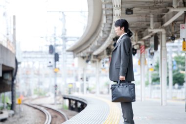 Tren istasyonunda duran Asyalı adam. 