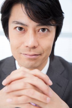 Ofiste çalışan kendinden emin genç Japon işadamı.