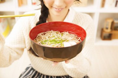 Yemek çubuğuyla erişte yiyen bir kadın. 