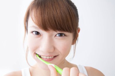 Dişlerini fırçalayan Asyalı kadın.