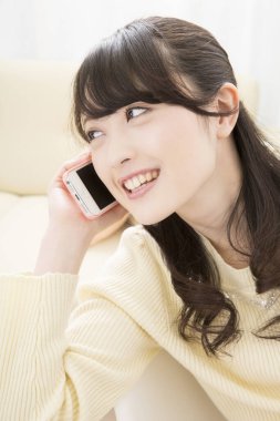 Akıllı telefondan konuşan gülümseyen Asyalı kadın, yakın plan portre 