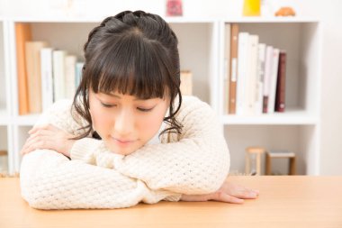 Evdeki masada oturan üzgün kadın 