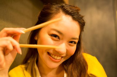 Restoranda çubuklu Asyalı bir kadının portresi.