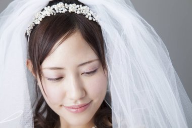 Beyaz gelinlik içinde güzel Asyalı gelin. 