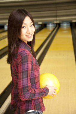 Elinde bowling topu tutan Asyalı kadın.