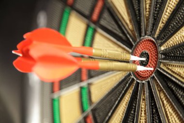 Tahtadaki oklarla hedefi dartlar.  