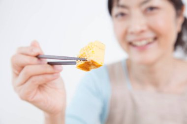 Asyalı kadın yemek yiyor.