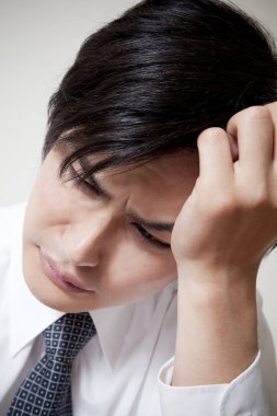 Genç Asyalı işadamının başı ağrıyor.