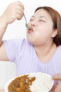 Sağlıksız yiyecekler yiyen şişman bir kadın.