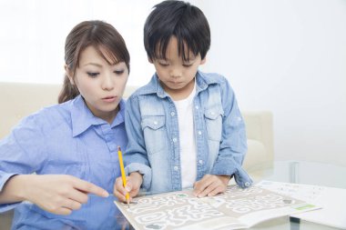 Asyalı anne ve oğul ödev yapıyor.