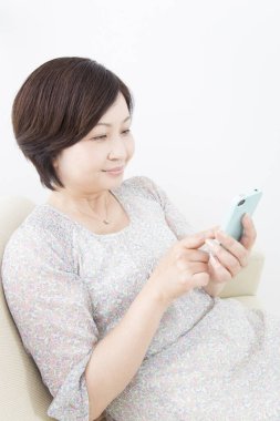 bir akıllı telefon kullanan Asyalı kadın