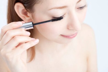 Maskara süren genç Asyalı kadın.