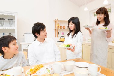 Dört kişilik aile evde öğle yemeği yiyor.