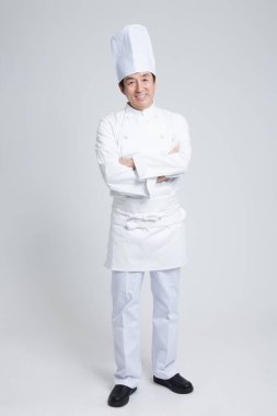 Beyaz arka planda Asyalı üniformalı bir adam.