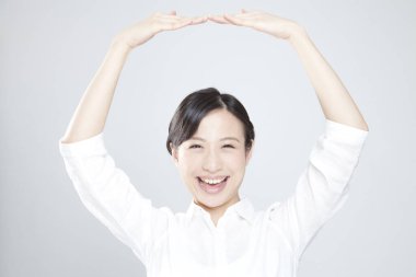 Genç ve güzel Asyalı kadın ellerini kaldırdı. 