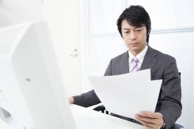 Ofiste çalışan kendinden emin genç Japon işadamı.