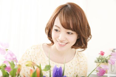 Çiçeklerle gülümseyen güzel Asyalı kadın