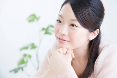 Kapalı alanda gülümseyen genç Asyalı kadın.