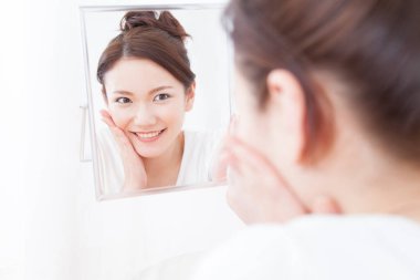 Banyoda aynalı Asyalı kadın.