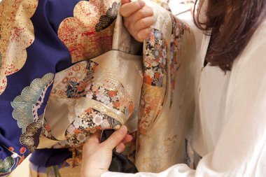 Kadın kadına geleneksel Japon kimonosu giymesi için yardım 