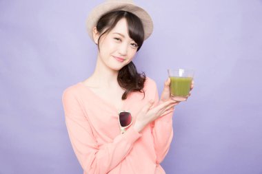 Elinde yeşil kibrit çayı tutan kadın.